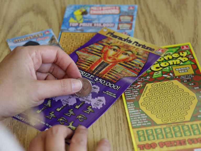 close up of hands scratching a Pharaoh's Fortune Scratch-it ticket