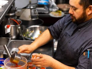 A man preps food in a commercial kitchen